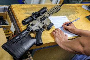 California gun shop: buyer signs paperwork for an AR 15 rifle, state regulations