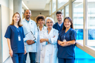 Medical team smiling at camera in hospital corridor