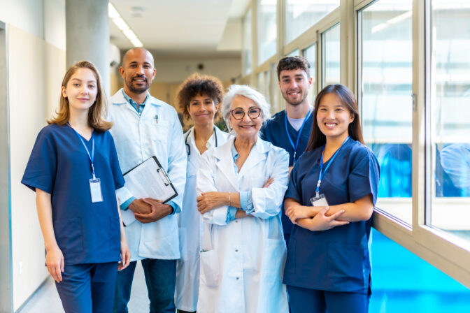 Medical team smiling at camera in hospital corridor