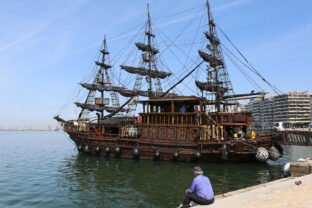 Man fishing by The Tour Ship in Thessaloniki, Greece