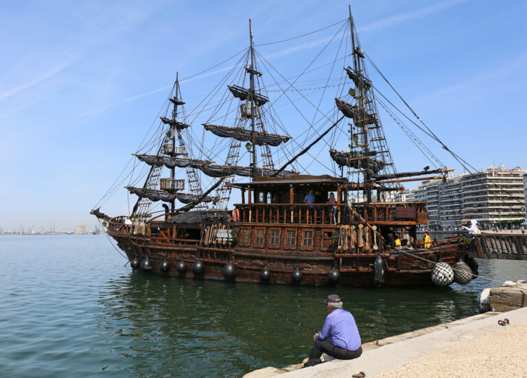 Man fishing by The Tour Ship in Thessaloniki, Greece