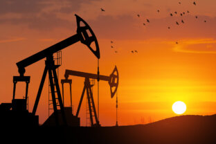 Oil drilling derricks at desert oilfield. The change in oil prices caused by the war. Oil price cap concept.