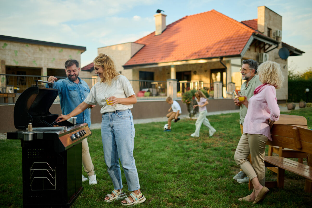 Happy family having barbecue party in backyard,