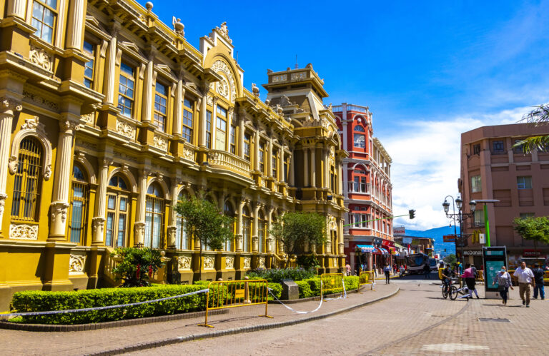 Farebná ulica s autami, obchodmi, budovami, domami, architektúrou a ľuďmi v meste Merced San José, Kostarika, v Strednej Amerike.