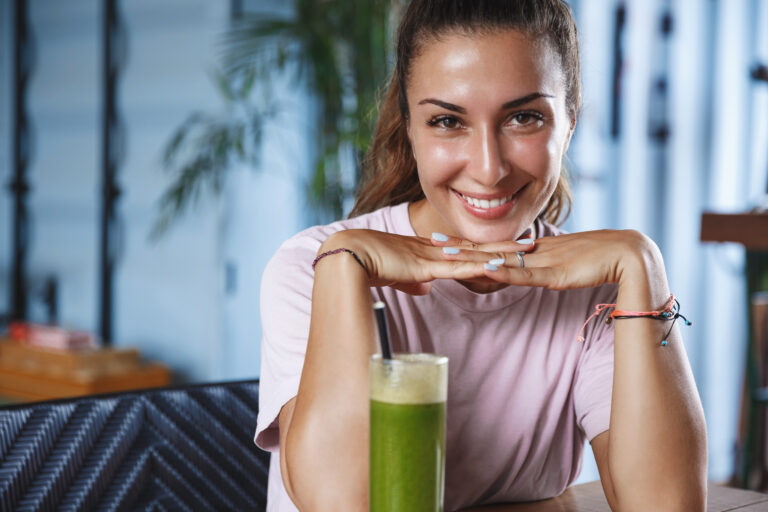Romantic dates, leisure concept. Attractive adult woman lean on hands coquettish gazing in your eyes, smiling as sit together at cafe, drink smoothie, on tropical island vacation, travel around world