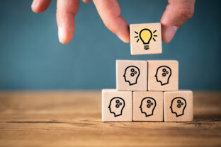 Many people together having an idea symbolized by icons on cubes
