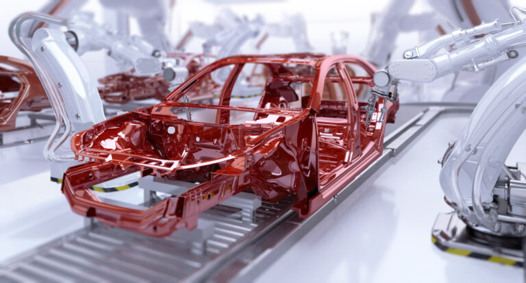 Automated car manufacturing. Industrial robotic arms painting vehicle body on a production line.