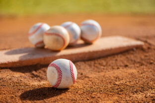 Several baseballs on pitcher's mound at youth league field