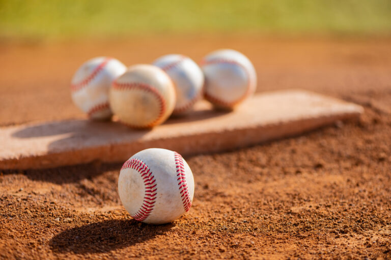 Several baseballs on pitcher's mound at youth league field