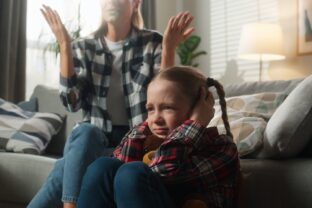 Family domestic violence trouble frustrated little child girl kid daughter close ears with hands at home with angry furious mother woman babysitter scold talking argument conflict psychology problem