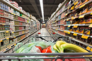 Close up of shopping cart in supermarket aisle.