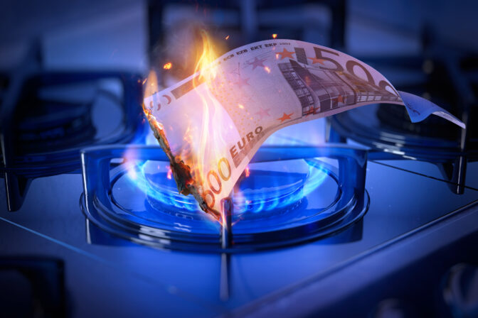 Euro banknote burning over a gas stove flame symbolizing energy crisis