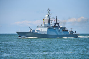 Battleship war ship boat corvette with helicopter on deck in beautiful blue sea. Navy warship