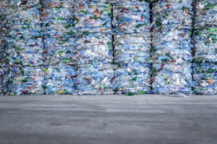 Large pile of plastic PET bottles compressed and ready for recycling. Separating and sorting garbage for modern recycle plant.