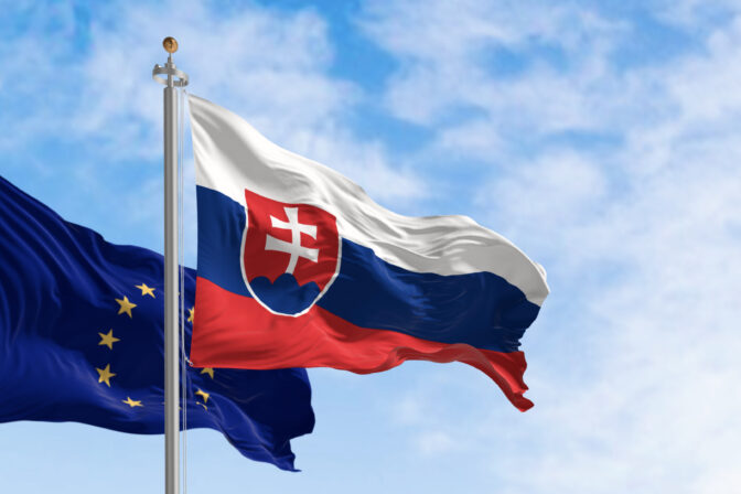 Slovakia and the European Union flags waving in the wind on a clear day