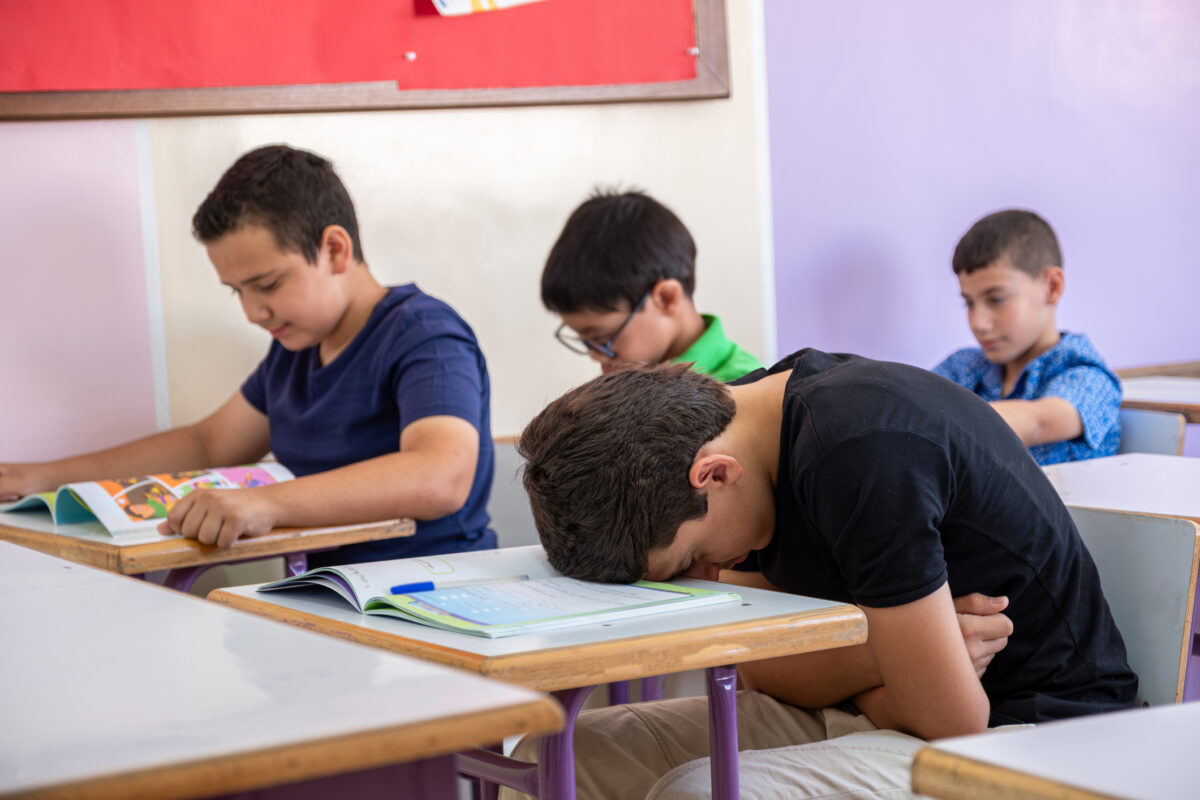 Student putting his head on the desk ,looks not feeling well or sleeping