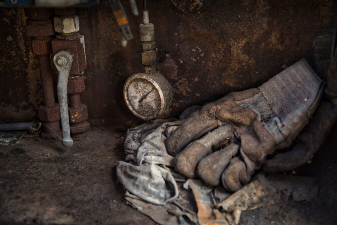 End of work, end of work shift, work glove in an old steelworks and coking plant in an atmospheric ambience. Dusty and abandoned. Inspiration from a European factory that was demolished and lost in history. Belgium. Seraing