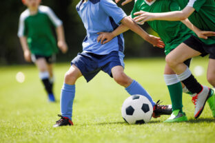 Youth Soccer Match.  Kids Playing Football on Grass Field in Team Uniforms. Children Sports Activity and Competition