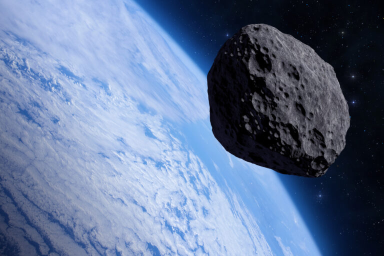 Blue Earth and big asteroid in outer space.