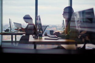 Busy corporate office silhouettes at cityscape window closeup. People working