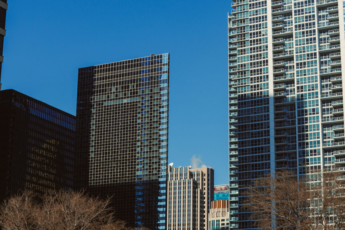 Skyscrapers reach high in the bright blue sky on a clear day in an urban setting