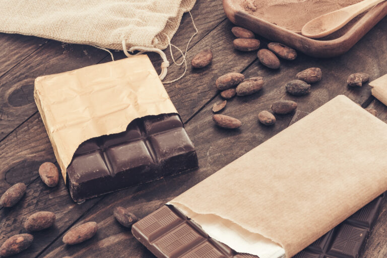 Chocolate bar with cocoa beans wooden table.jpg