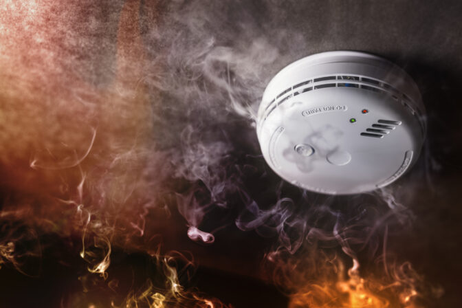 Smoke detector and fire alarm in action background
