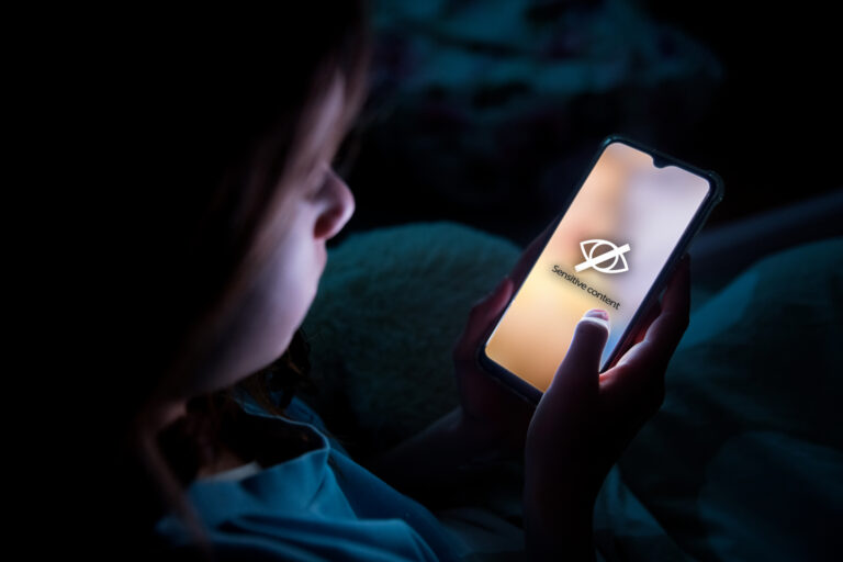 A child using smart phone lying in bed late at night