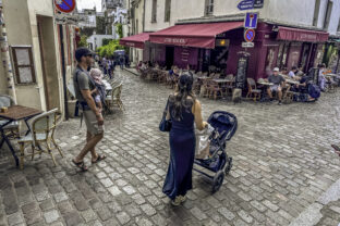 Young Parents Carrying Baby Stroll Through Rue Poulbot in Montmartre Paris France