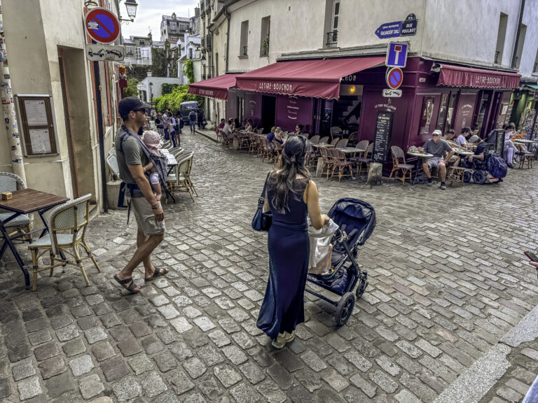 Young Parents Carrying Baby Stroll Through Rue Poulbot in Montmartre Paris France