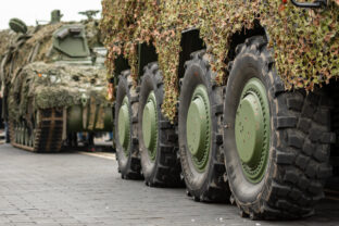 Column of various armoured tanks moving on the road