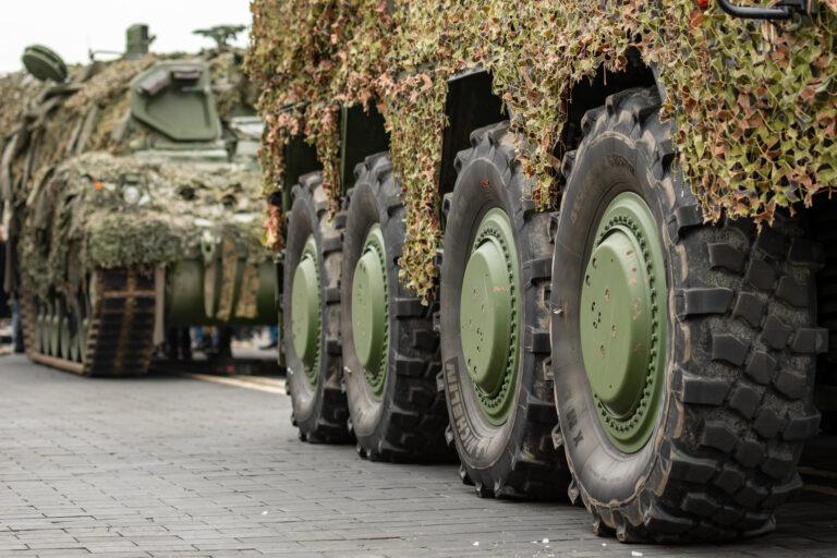 Column of various armoured tanks moving on the road