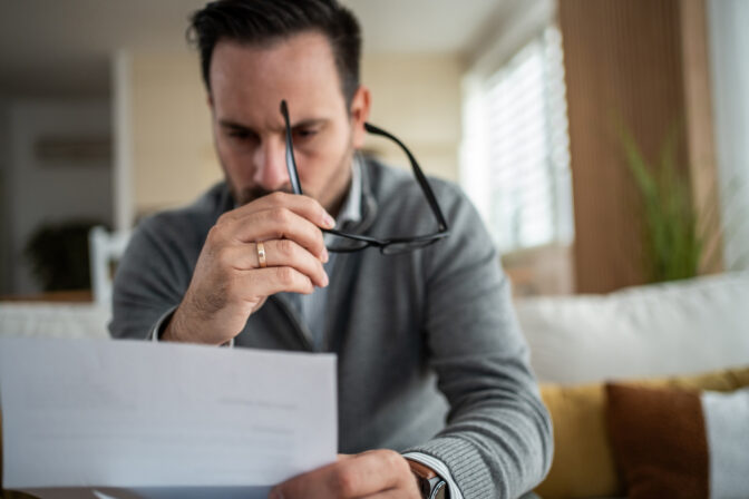 Man reading document feeling worried and stressed