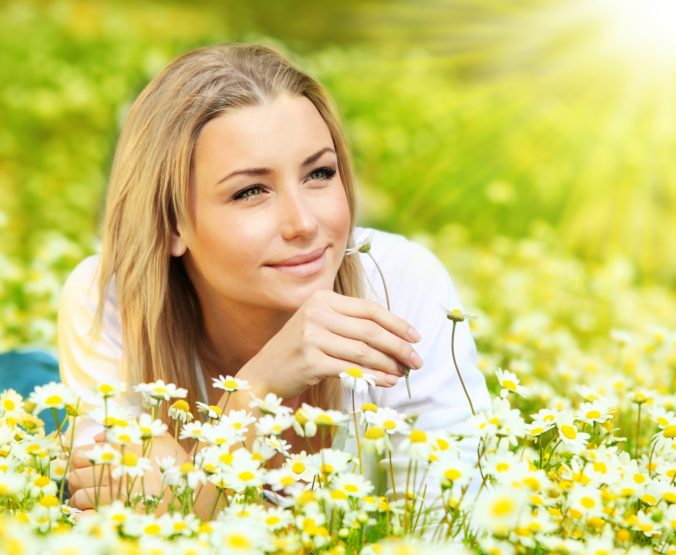 87042_young beautiful girl laying on the daisy flowers field outdoor portrait small 676x555.jpg