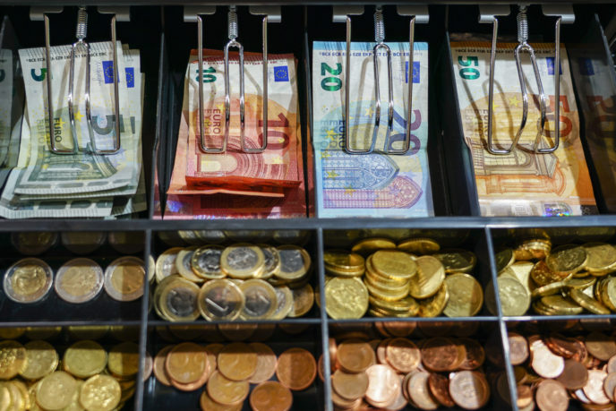 Open cash register drawer closeup with money
