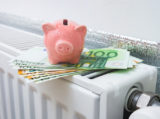 Domestic radiator heating with piggy bank on euro banknotes. Save heating costs concept image.