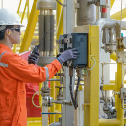 Plyn plynovod dodavky Production operator operating centrifugal oil pump by using local mode to start and another hand using walkie talkie to talk with central control room, offshore oil and gas industry business.