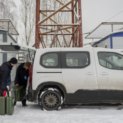 Technicians Yuriy Dugnist, right, and Oleksandr Puhlenko, of Ukrainian mobile telephone network operator Kyivstar, deliver jerrycans with fuel to a phone tower on the outskirts of Kyiv, Ukraine, Wednesday, Nov. 30, 2022. With Ukraine racing to keep communications lines open in wartime, the country's phone operators have mobilized more than usual to help people stay in touch — such as by revving up generators to power mobile towers after Russian strikes took out the electricity they usually run on