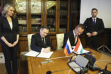 In this handout photo released by Communications Department of Rosatom, Alexey Likhachev, Director General of State Atomiс Energy Corporation Rosatom, left, and Peter Szijjarto, Minister of Foreign Affairs and Trade of Hungary sign a document during their meeting in Moscow, Russia