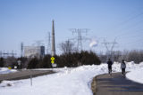 People walk on a trail at the Montissippi County Park near the Xcel Energy Monticello Generating Plant, a nuclear power plant, in Monticello, Minn