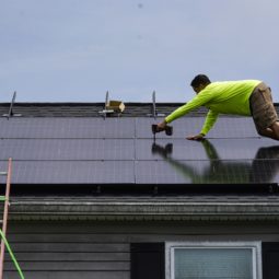 Nicholas Hartnett, owner of Pure Power Solar, secures solar panel on the roof of a home in Frankfort, Ky., Monday, July 17, 2023. Since passage of the Inflation Reduction Act, it has boosted the U.S. transition to renewable energy, accelerated green domestic manufacturing, and made it more affordable for consumers to make climate-friendly purchases, such as installing solar panels on their roofs