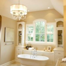 Traditional bathroom in miami with a freestanding tub and beautiful window surrounded by cabinets.png