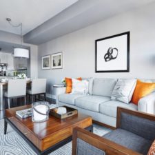 Post_an attractive grey sofa with tasty orange cushions and classic wooden table with artistic wall decors also white archlamp for excellent living room interior design.jpg