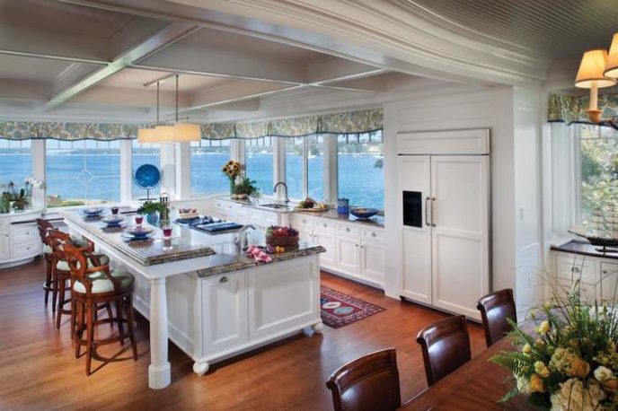 Post_large kitchen interior with white cabinetry and a big kitchen island also marble dining space with lovely stools decorated by wide windows for panoramic sea and classic lamps.jpg