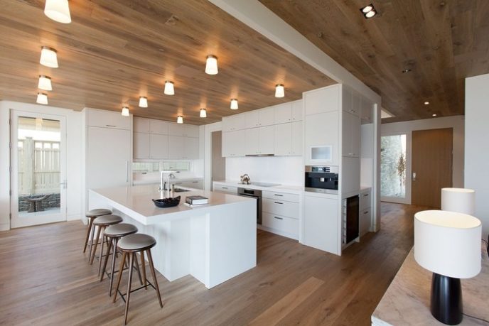 Post_wood ceiling with contemporary lighting fixtures and glossy white kitchen island and industrial stools.jpg