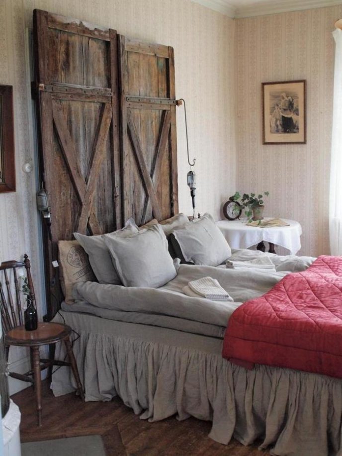 Post_bed with pillows also rustic wooden headboard with small side lamps along with round table and wooden chair decorated by wallpaper design.jpg