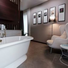 Post_art deco influences for the contemporary bathroom with freestanding bathtub side table and cozy chair.jpg