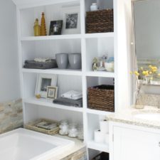 Post_white wooden bathroom shelf over bathtub with rattan wicker storage basket plus white vanity cabinet with sink.jpg