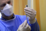 A health worker prepares a vaccine after the first batch f the Pfizer-BioNTech vaccines against the new coronavirus bought by Hungary arrived at the Southern Pest Central Hospital in Budapest, Hungary, Saturday, Dec. 26, 2020. The first shipment of vaccines produced in Puurs, Belgium, contains 9,750 doses and will be distributed to other hospitals from here to be administered to 4,875 healthcare workers in Hungary.