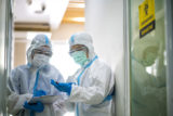 Asian doctor checking coronavirus or covid 19 infected patient in quarantine room